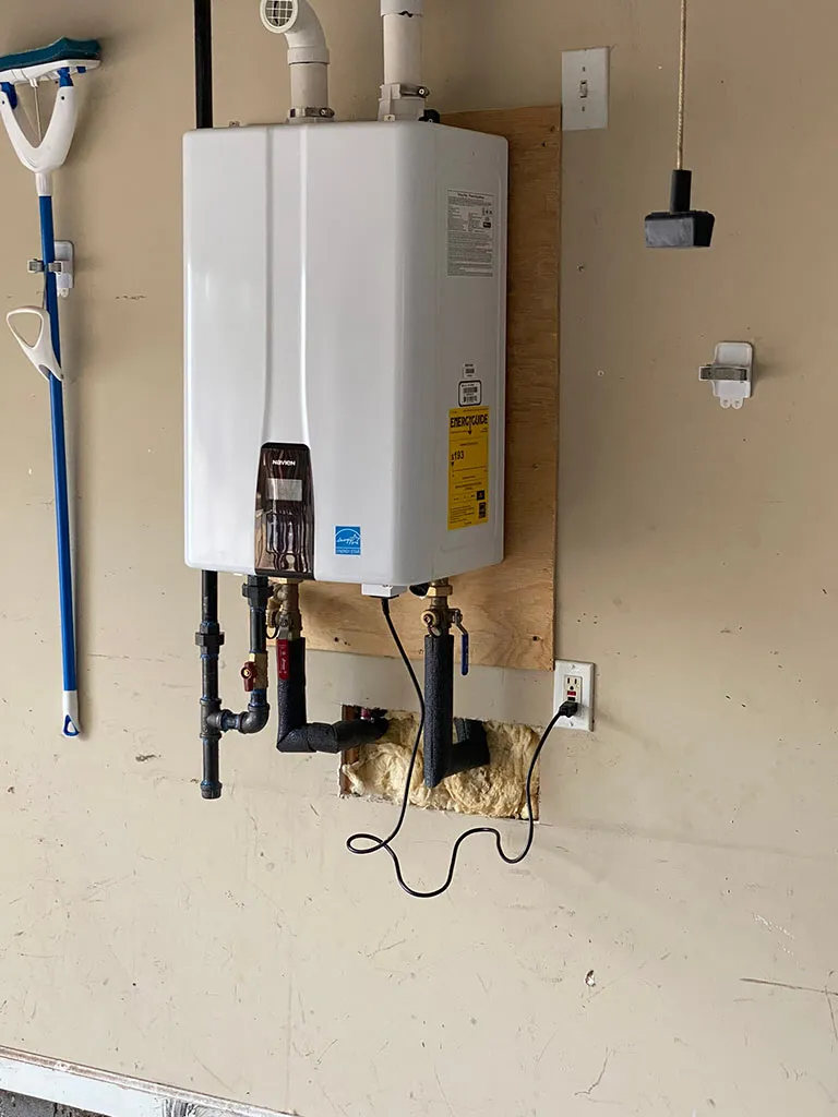 Tankless water heater mounted on a garage wall