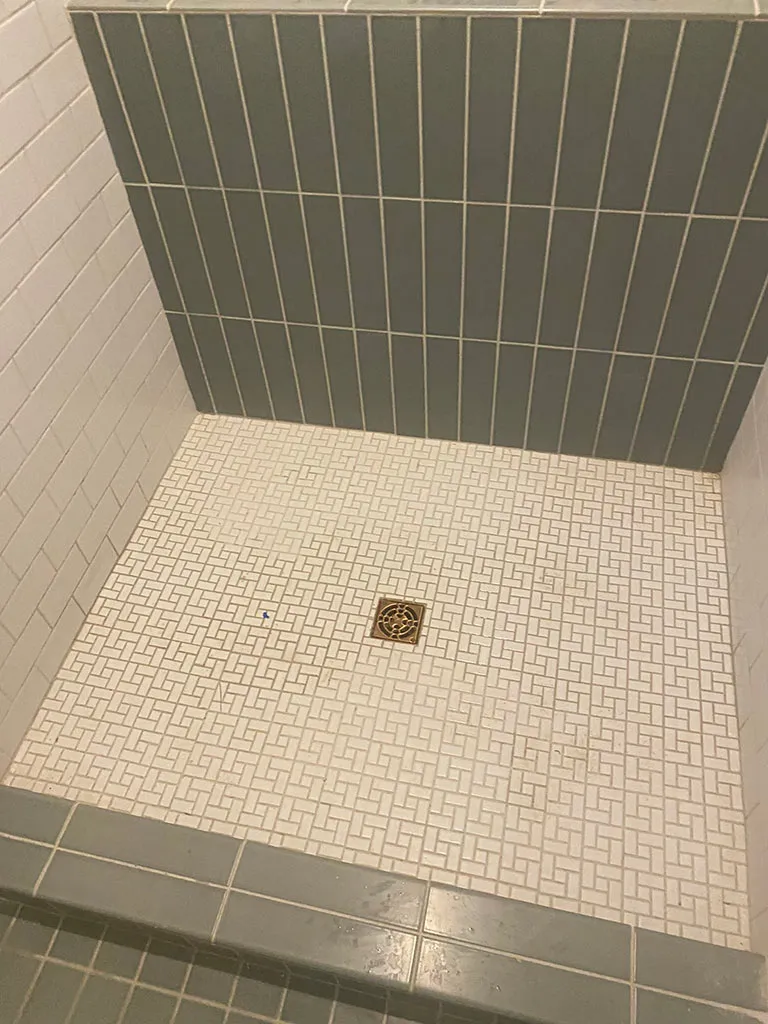 New tiled shower floor with a brass drain
